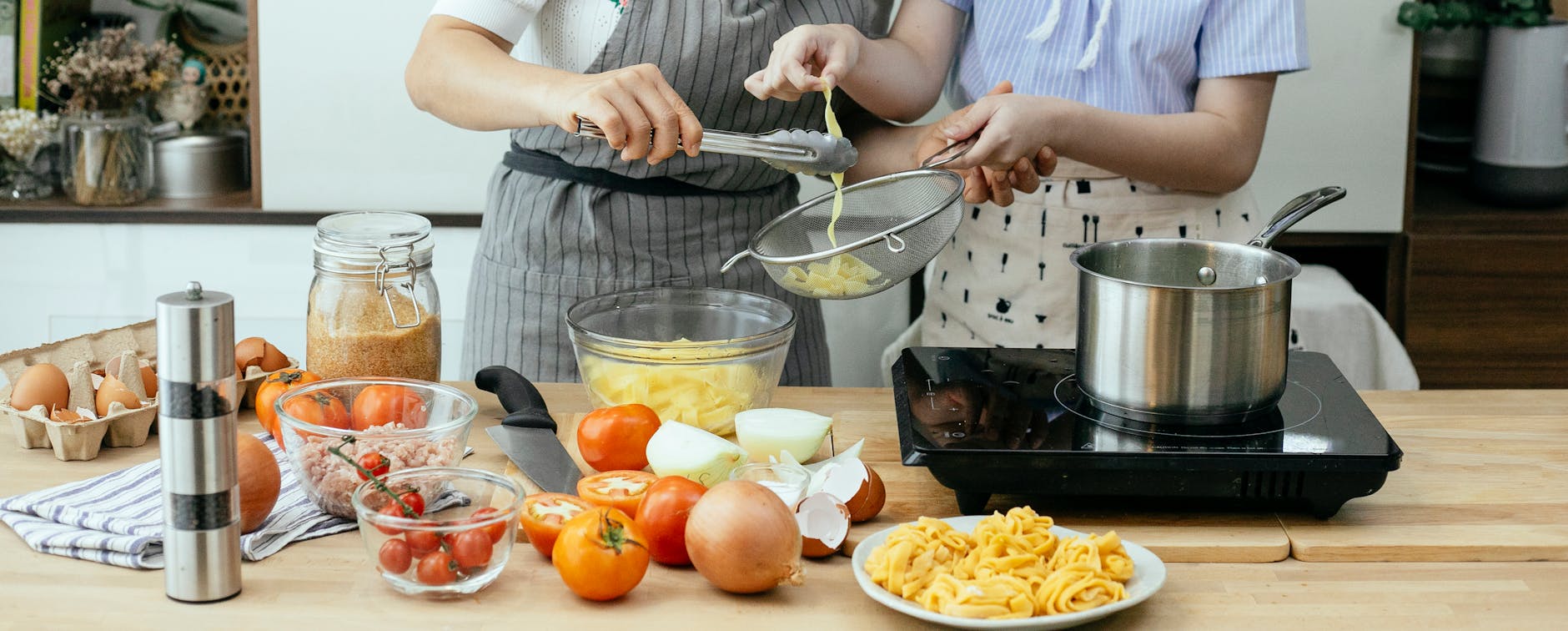 crop women cooking pasta in kitchen