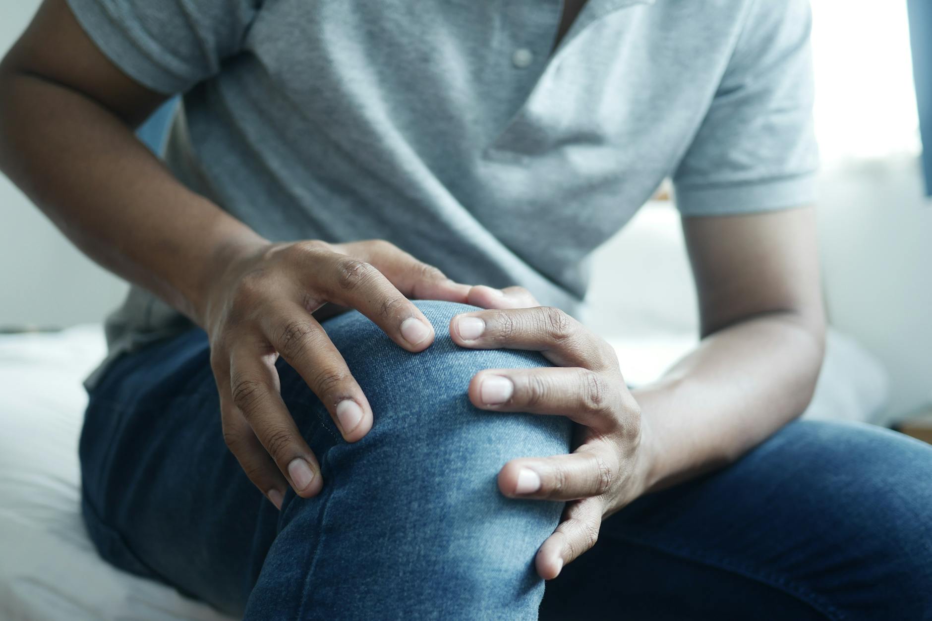 a person in gray shirt and blue denim jeans